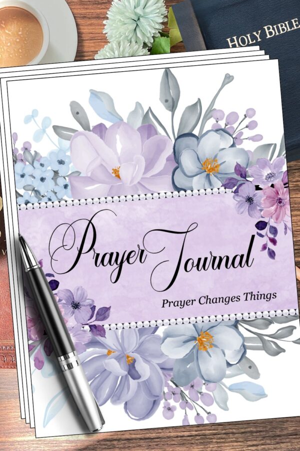 Flat lay image of a floral-themed “Prayer Journal” with the phrase “Prayer Changes Things” on a soft lavender background. Surrounded by purple, blue, and white flowers, the journal sits on a wooden surface next to a silver pen, a cup of coffee, white flowers, and a Holy Bible.